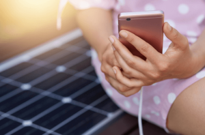 Free photo image of faceless woman in pink dress charging her smart phone